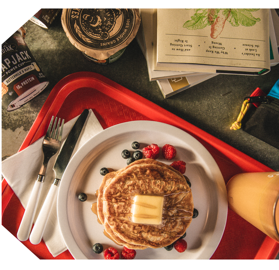 Food service channels - a college dining tray with pancakes, fresh fruit and orange juice. On the go kodiak snacks sit behind it